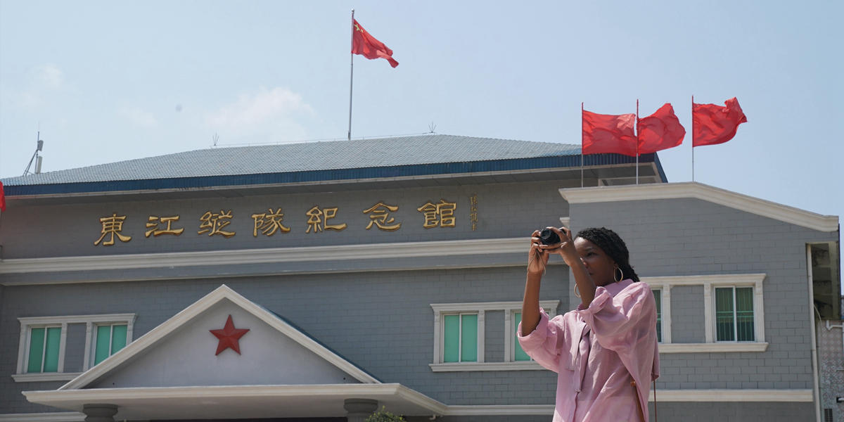 Reckelle Mason from the U.S. takes photos in front of the Dongjiang Guerrilla Column Memorial Hall