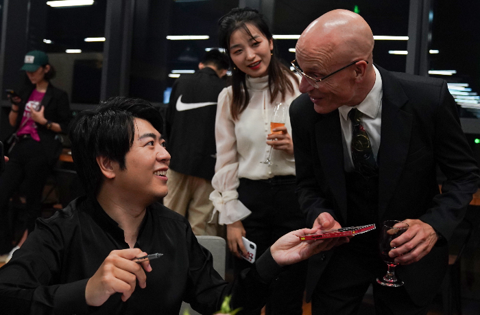 Lang Lang (L) delivers an autographed album to Brian Little, a teacher from Shenzhen College of International Education..jpg